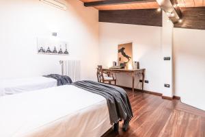a bedroom with two beds and a desk at [Chardonnay]- elegante appartamento in Cavezzo +14 photos