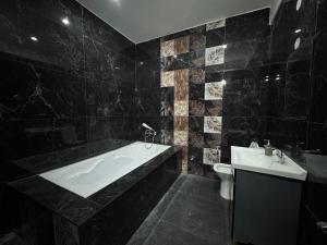 a black bathroom with a tub and a sink at Shivoham Retreat in Dehradun