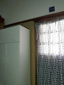 ventana en una habitación con cortina y nevera en Room Parow, Cape Town, en Cape Town