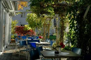 an outdoor patio with tables and blue chairs at Hotel Engel in Ulm