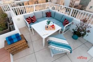 an apartment balcony with a couch and a table at Spinola Stays in St. Julianʼs