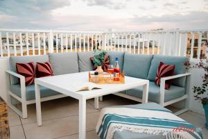 a couch and a table on a balcony at Spinola Stays in St. Julianʼs