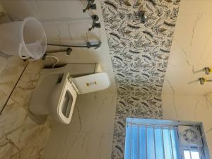 a bathroom with a toilet and a mirror in it at Inn34 By Blessings Hospitality - Porur Near DLF in Chennai