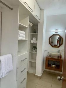 a white bathroom with a sink and a mirror at Casa entera en fraccionamiento bahia azul in Mezcales