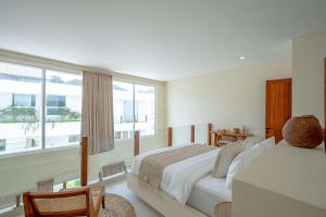 a bedroom with two beds and a large window at Lyma Loft Pererenan in Canggu