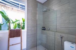 a bathroom with a shower with a glass door at Lyma Loft Pererenan in Canggu +29 photos