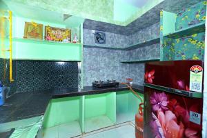 a kitchen with green and purple walls and a counter at Manohar's Homestay in Tirupati