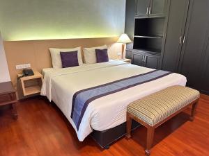 a bedroom with a large white bed with purple pillows at Collection O The Step Sathorn in Bangkok +64 photos