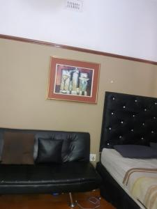 1 dormitorio con 1 cama y 1 sofá de cuero negro en Room Parow, Cape Town, en Cape Town