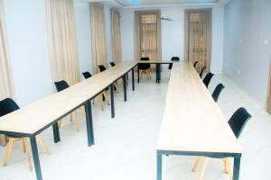 a long row of tables in a room with chairs at Caritas Inn, Ilasan in Lagos