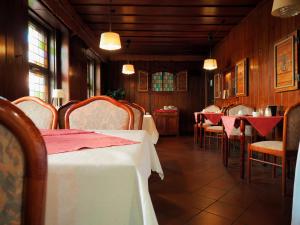 a dining room with tables and chairs with red napkins at Hotel zur Sonne in Cottbus