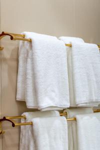a group of white towels on a rack in a bathroom at Kaibu Courtyard Superior Apartment, Changjiang Cable Car Nanbin Road, Chongqing in Chongqing