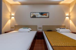 a room with two beds and a picture on the wall at Kaibu Courtyard Superior Apartment, Changjiang Cable Car Nanbin Road, Chongqing in Chongqing