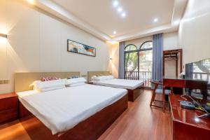 a bedroom with two beds and a desk and a television at Kaibu Courtyard Superior Apartment, Changjiang Cable Car Nanbin Road, Chongqing in Chongqing