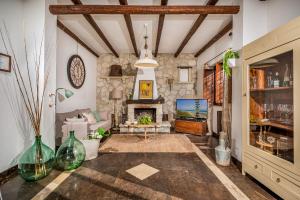 salon z kamiennym kominkiem i telewizorem w obiekcie Il Giardino Dei Limoni 8, Emma Villas w mieście Ispica