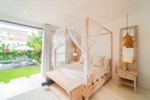 1 dormitorio con cama con dosel y ventana grande en Kokomo Villas by Aayan, en Canggu 92 fotos más