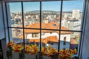 a view of a city from a window with plants at Guest House Malusha in Gabrovo