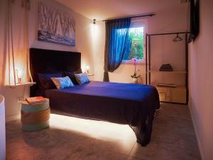 a bedroom with a bed with blue sheets and a window at RedHouse Benaco in Torri del Benaco