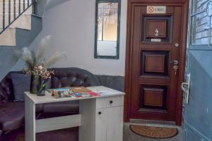 a living room with a table and a door at Guest House Malusha in Gabrovo