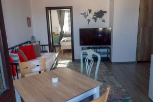 a living room with a table and a tv at Guest House Malusha in Gabrovo