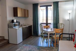 a kitchen and dining room with a table and a microwave at Guest House Malusha in Gabrovo