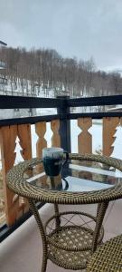 a coffee cup sitting on a table on a balcony at Trialeti Sweet Home in Bakuriani