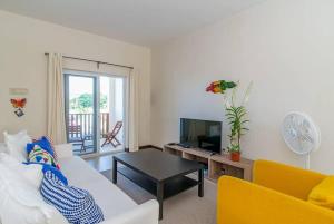 a living room with a couch and a tv at Hospitality Expert CB All Pool Beach in Montego Bay