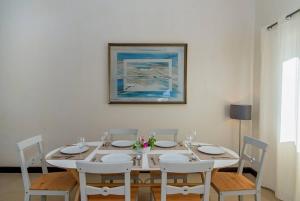 a white dining room table with chairs and a painting at Hospitality Expert CB All Pool Beach in Montego Bay +128 photos