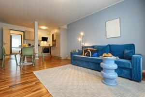 ein Wohnzimmer mit einer blauen Couch und eine Küche in der Unterkunft homie hotel max apart - Fürth in Fürth