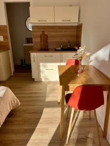 eine Küche mit einem Holztisch und 2 roten Stühlen in der Unterkunft Studio paisible dans un quartier calme in Marguerittes + 7 Fotos