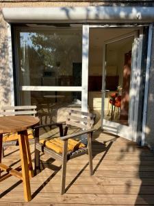 eine Terrasse mit einem Tisch und einer Bank auf einer Terrasse in der Unterkunft Studio paisible dans un quartier calme in Marguerittes