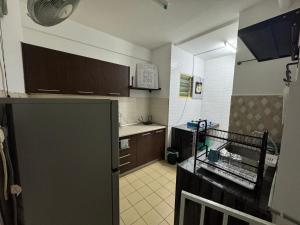 a kitchen with a refrigerator and a sink in it at Sweet Home inn Tasik Biru Kundang in Rawang