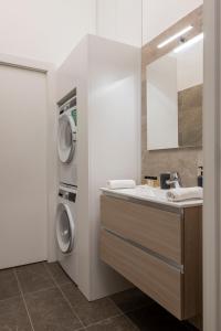 a bathroom with a sink and a washing machine at Argonne 51 Spazio Argonne studio apartment in Milan +30 photos
