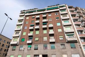 a tall brick building with lots of windows at Argonne 51 Spazio Argonne studio apartment in Milan
