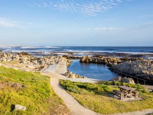 a picnic table and a bench on the beach at Two Palm House - Vermont Hermanus in Hermanus