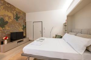 a bedroom with a large white bed and a tv at Argonne 51 Spazio Argonne studio apartment in Milan