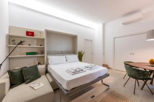a bedroom with a bed and a couch and a table at Argonne 51 Spazio Argonne studio apartment in Milan