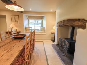sala de estar con mesa de madera y estufa de leña en Green Yew, en Windermere