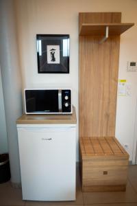 a microwave sitting on top of a refrigerator at Hôtel de la gare in Choisy-le-Roi +34 photos