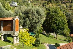 a garden with a house and trees and a pool at Casa São Miguel Arcanjo in Caniçada