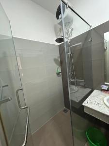 ein Bad mit einer Dusche, einem Waschbecken und einer Duschkabine aus Glas in der Unterkunft Canterbury Golf Resort Apartments and Residencies by Home Lands Skyline in Gonapola