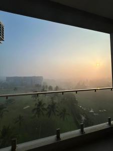 ein Fenster mit Blick auf ein Feld mit Palmen in der Unterkunft Canterbury Golf Resort Apartments and Residencies by Home Lands Skyline in Gonapola