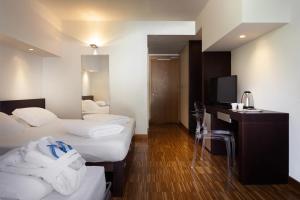 a hotel room with two beds and a television at Astoria Resort in Riva del Garda