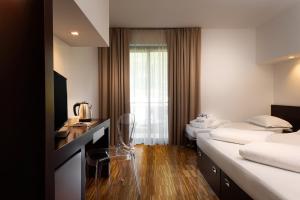 a hotel room with two beds and a television at Astoria Resort in Riva del Garda