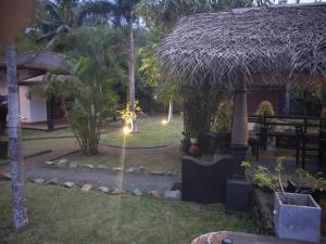 a resort with a grass roof and a garden at New Coco cabana in Bentota