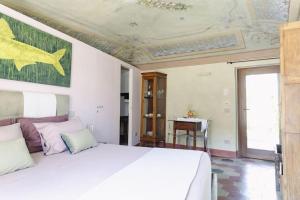 une chambre avec un grand lit blanc et une table dans l'établissement Eramare - Charming Suite in the Countryside, à Asti