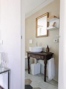 La salle de bains est pourvue d'un lavabo et d'un miroir sur une table. dans l'établissement Eramare - Charming Suite in the Countryside, à Asti