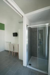 a glass shower in a room with a table and chairs at B&B Dietro il Teatro in Palermo