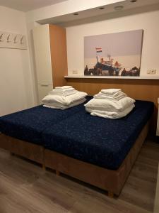 2 letti in una camera con materasso blu di Appartement Noflik, Amelander Kaap a Hollum