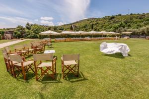 a group of tables and chairs in a field with umbrellas at Villa Irlanda Grand Hotel in Gaeta